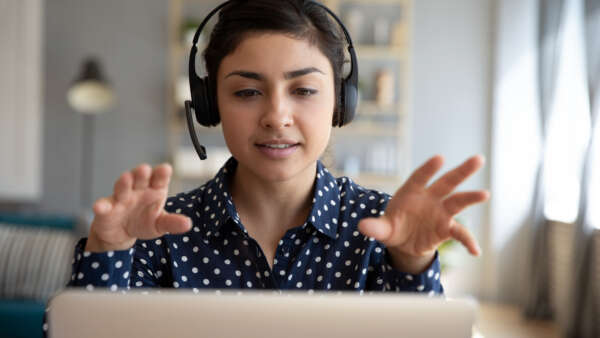 female wear wireless headset video calling on laptop