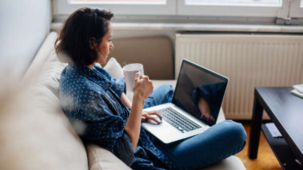 Cropped image of woman using laptop with blank screen