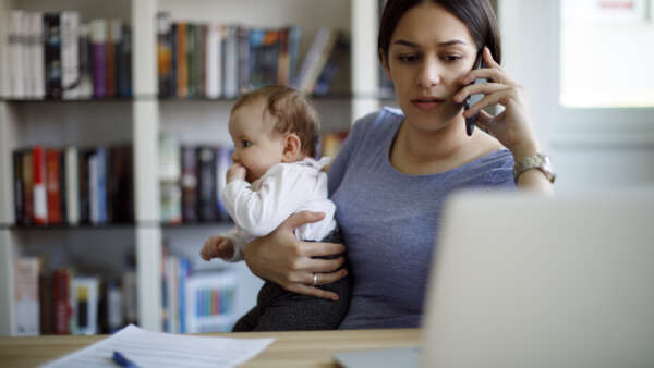 Worried mother using mobile phone an laptop at home