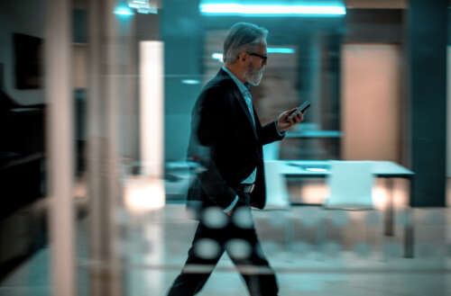 Businessman talking on phone while walking