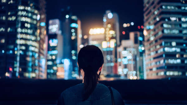 Rear view of woman looking at city at night